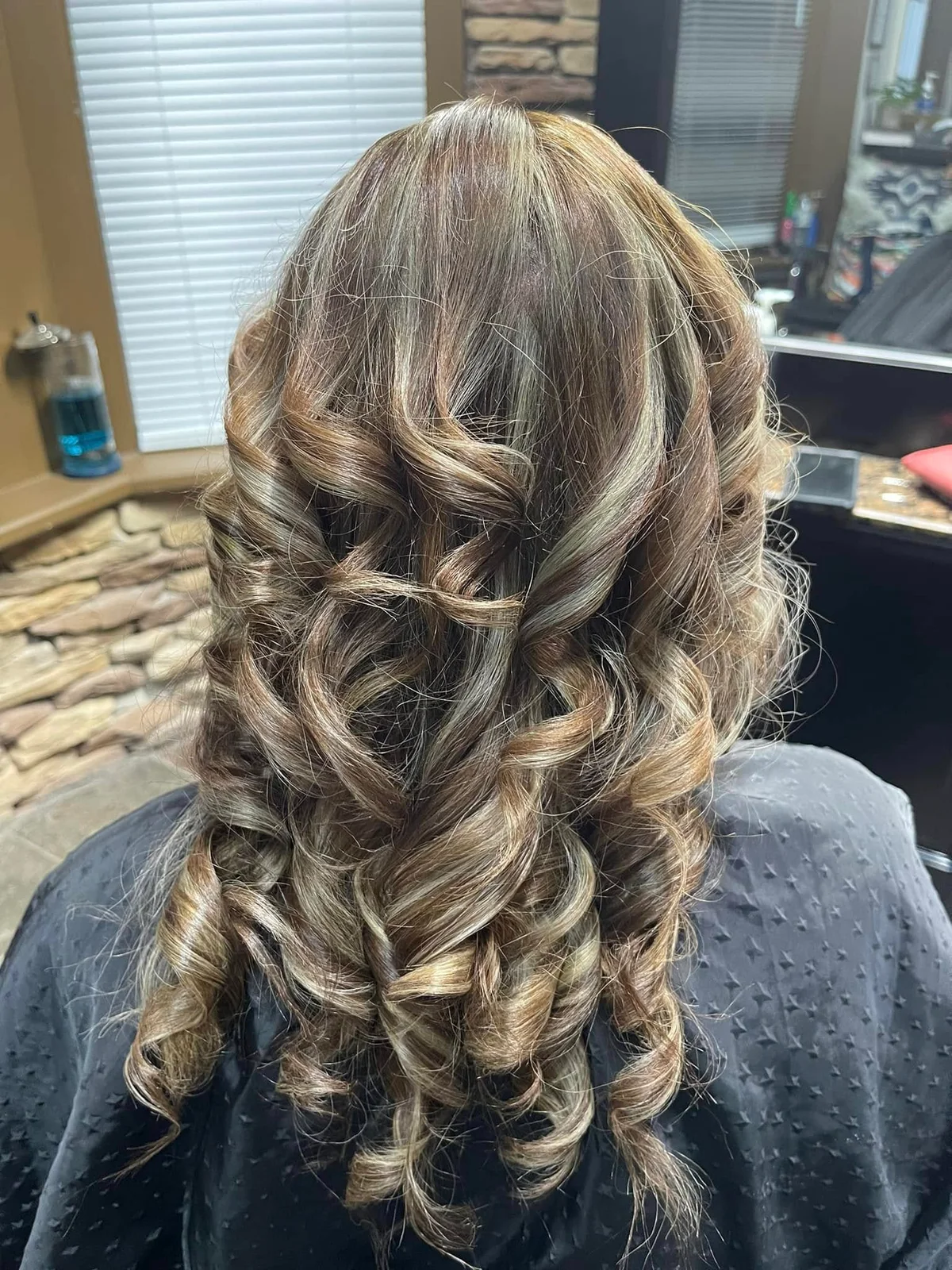 Blonde highlights and flowing curls at Innovations Beauty Salon